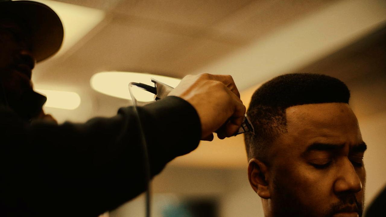 Barber at RDH Barbers concentrating on a fade haircut in the Kensington Market shop